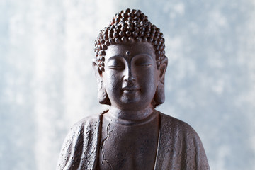 Meditating Buddha Statue on bright background.