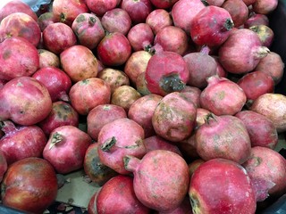 Piles of deep pink pomegrenate fruits.