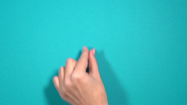 Closeup top view 4k video of beautiful manicured female hand making gesture with her two fingers as if minimizing virtual page at screen of tablet pc or smartphone.