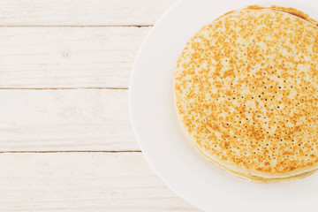 pancakes on plate on white wooden background