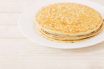 pancakes on plate on white wooden background
