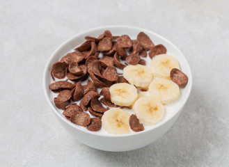 Crispy chocolate flakes in a bowl with milk and banana. Delicious healthy Breakfast