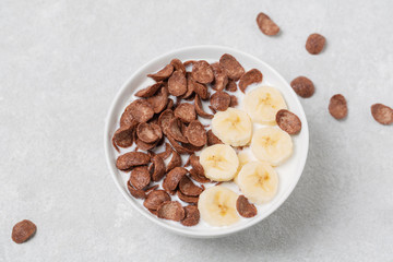 Crispy chocolate flakes in a bowl with milk and banana. Delicious healthy Breakfast