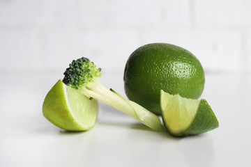 Fresh tasty broccoli and lime on light beige background