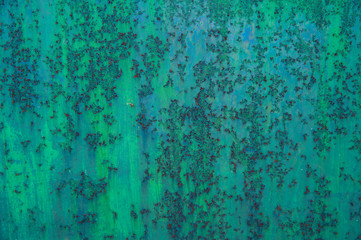 Bright streaks of blue-green paint on an old metal surface with picturesque rust spots and scratches. Abstract background, texture.