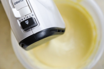 Close-up of a mixer making cream for preparing delicious home-made baking, focus on the mixer. - 326941482