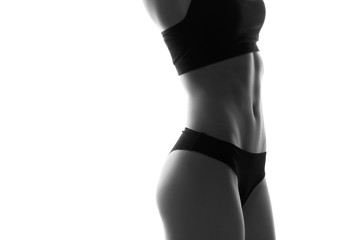 Sexy slim fit woman body with dumbbells. Muscled abdomen. Sportswear. Isolated on white. Black and...
