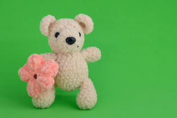 Knitted toy pink mouse on a green background