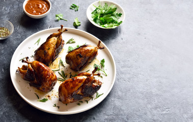 Roasted quails on white plate