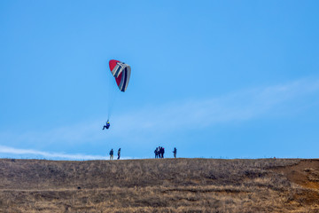 Skydiver On Colorful Parachute In Sky. Active Hobbies