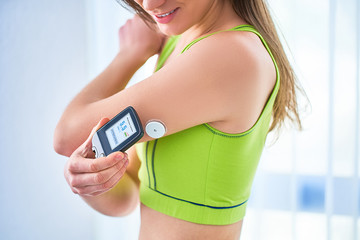 Woman diabetics control and checking glucose level with a remote sensor. Monitoring glucose levels without blood. Technology in diabetes treatment. Healthcare and medicine - obrazy, fototapety, plakaty