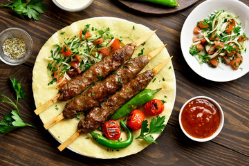 Turkish Adana Kebab with fresh vegetables on flatbread
