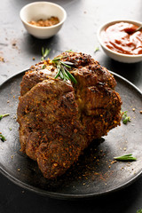 Barbecue meat. Grilled beef on plate over black stone background. Close up view