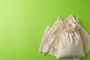 Cotton eco bags on light green background, flat lay. Space for text