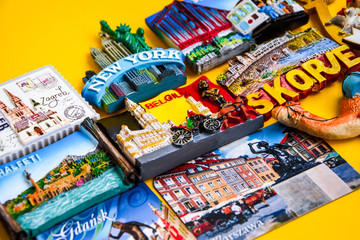 Magnets from different countries on yellow background, travel concept