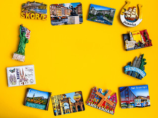 Magnets from different countries on yellow background, travel concept, copy space