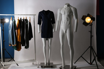 Ghost mannequins, clothes and professional lighting equipment in modern photo studio