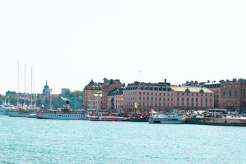 Naklejka premium Stockholm, Sweden June 7 2019: Beautiful panorama of the promenade in Stockholm, Sweden. The delightful architecture of the houses. Big and small boats, ships stand at the pier on a sunny day