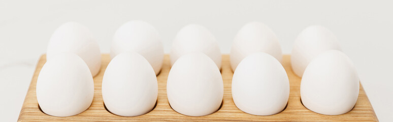 Wooden board with chicken eggs on white background, panoramic shot
