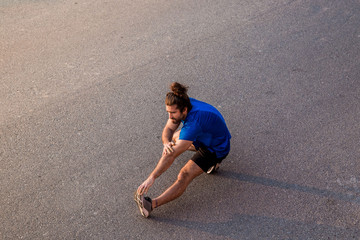 young man streching before running