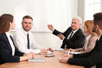 Senior business trainer working with people in office