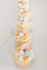 Selective focus of delicious easter cupcakes on white background