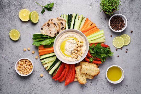 Hummus plate with a variety of vegetables and bread. Healthy snack or meze