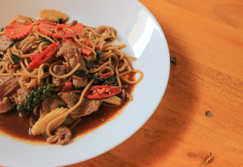 Black pepper spaghetti and wooden background
