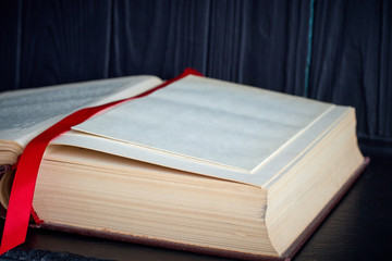 open old book with a red bookmark on a dark background