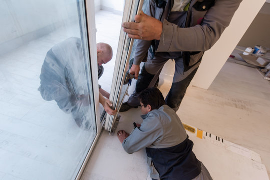 Carpenters Installing A Balcony Door