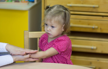 Portrait of caucasian child two years old making tactile exercises with teacher
