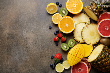 Assorted colorful fruits on the background. Fresh tropical fruits and berries