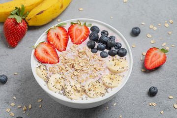 Healthy Breakfast smoothie bowl with strawberries, blueberries, banana, granola and Chia seeds.
