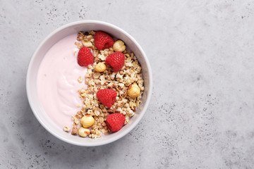 Raspberry yogurt with granola in a bowl. Nutritious snack or breakfast