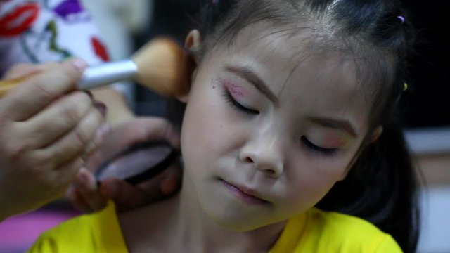 Mother  makeup her daughter , indoor  Chiangmai Thailand 