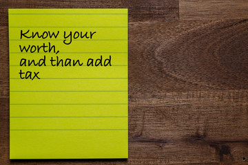 yellow sticker with lines on a dark wooden background with the handwriting of the wisdom of life:...