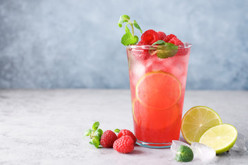 Raspberry lemonade with lime and ice. Cold refreshing cocktail
