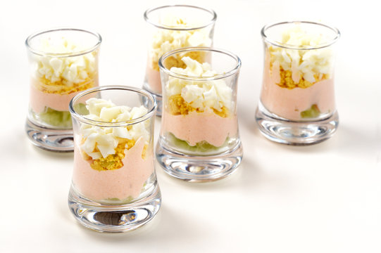Set of verrines ( French dish made with tasty, colorful layers, served in small glass) served on white table.
