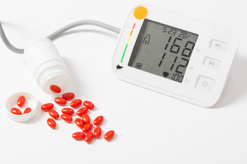 modern tonometer with pills on white background