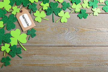 Flat lay composition with clover leaves on wooden table, space for text. St. Patrick's Day...