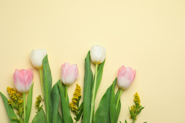 Flat lay composition with spring flowers on yellow background. Space for text