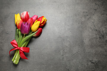Beautiful spring tulips on grey stone table, top view. Space for text