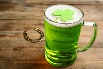 Green beer and clover on wooden table. St. Patrick's Day celebration