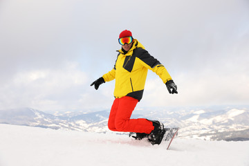 Fototapeta na wymiar Male snowboarder on snowy hill. Winter vacation