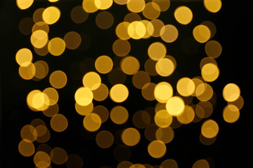 Blurred view of beautiful lights on black background. Bokeh effect