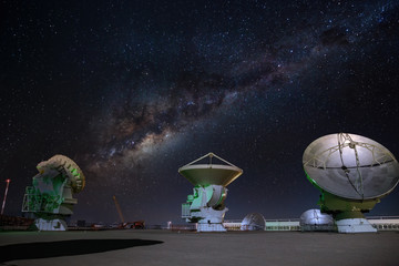 ALMA radio astronomy dishes watching the sky with milky way above