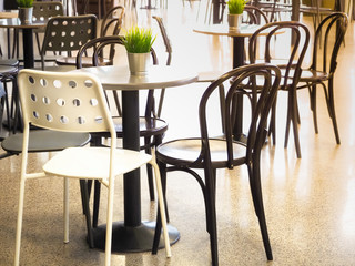 Simple retro style coffee shop interior with white and black chairs