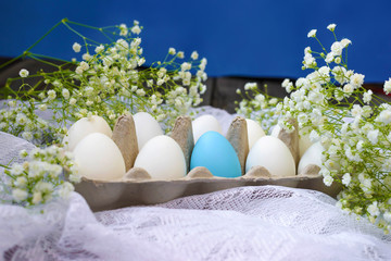 Happy Easter. White eggs in a stand on a wooden background with white gypsophila flowers. Holidays...