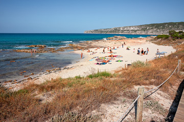Bathers sunbathing in the wild and sunny bays of Formentera in the Balearic islands of Spain.