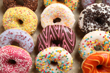 Yummy glazed donuts with sprinkles, closeup view